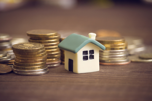 A little house by coin stacks